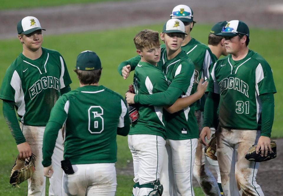 Edgar players console each other after their 4-3 loss to Ithaca in nine innings in a WIAA Division 4 state semifinal game Tuesday at Fox Cities Stadium in Grand Chute.