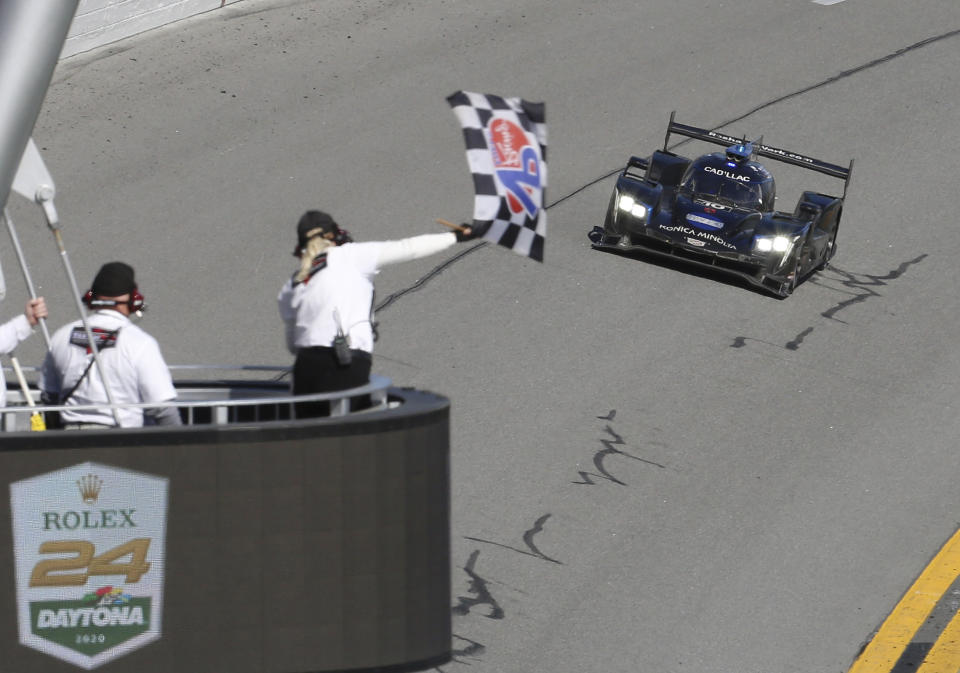 FILE - Konica Minolta Cadillac DPi-V.R driver Kamui Kobayashi takes the checkered flag to win the Rolex 24-hour auto race at Daytona International Speedway, Sunday, Jan. 26, 2020, in Daytona Beach, Fla. Kamui Kobayashi is rated as one of the best endurance racers in the world and returns to the Rolex 24 at Daytona seeking a third victory in the prestigious race. He's the reigning World Endurance Champion and winner of the 24 Hours of Le Mans, but wonders if this weekend's event in Daytona begins his final season of racing in the United States.(AP Photo/David Graham, File)