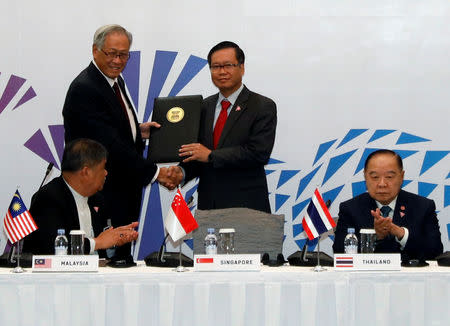 Singapore's Defence Minister Ng Eng Hen presents a signed joint declaration to ASEAN Deputy Secretary General Hoang Anh Tuan at the ASEAN Defence Ministers' Meeting in Singapore October 19, 2018. REUTERS/Edgar Su