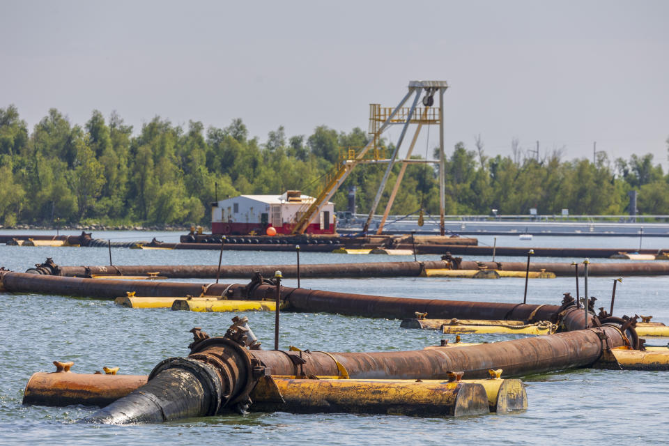 Pipes carrying sediment crisscross the Mississippi River where the U.S. Army Corps of Engineers is building an underwater sill with that mud that should slow the flow of saltwater up the Mississippi River south of New Orleans, Tuesday, Sept. 26, 2023. (Chris Granger/The Times-Picayune/The New Orleans Advocate via AP)