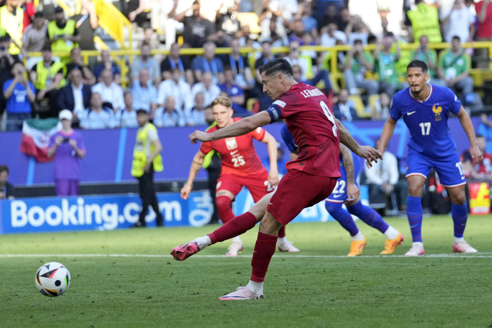 FILE -Poland's Robert Lewandowski retakes his penalty kick to score during a Group D match between the France and Poland at the Euro 2024 soccer tournament in Dortmund, Germany, Tuesday, June 25, 2024. The penalty shootout is a tense battle of wills over 12 yards (11 meters) that has increasingly become a huge part of soccer and an unavoidable feature of the knockout stage in the biggest competitions. (AP Photo/Sergei Grits, File)