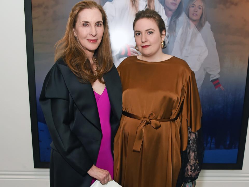 Laurie Simmons standing next to Lena Dunham with a painting behind them