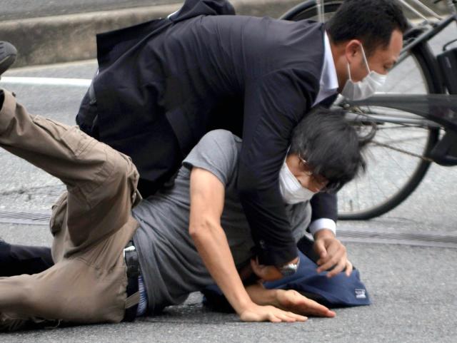 Suspect Tetsuya Yamagami is detained after the shooting of former prime minister Shinzo Abe in Nara Prefecture, western Japan, on Friday, 8 July (Katsuhiko Hirano/The Yomiuri Shimbun/AP)