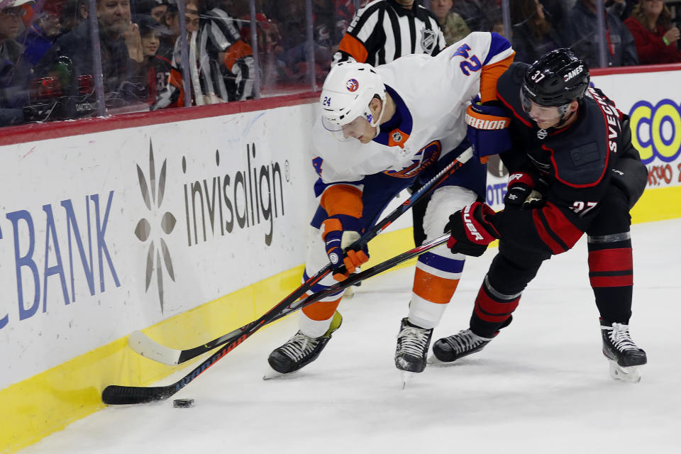 Carolina Hurricanes' Andrei Svechnikov (37), of Russia, battles with New York Islanders' Scott Mayfield (24) for the puck during the first period of an NHL hockey game in Raleigh, N.C., Sunday, Jan. 19, 2020. (AP Photo/Karl B DeBlaker)