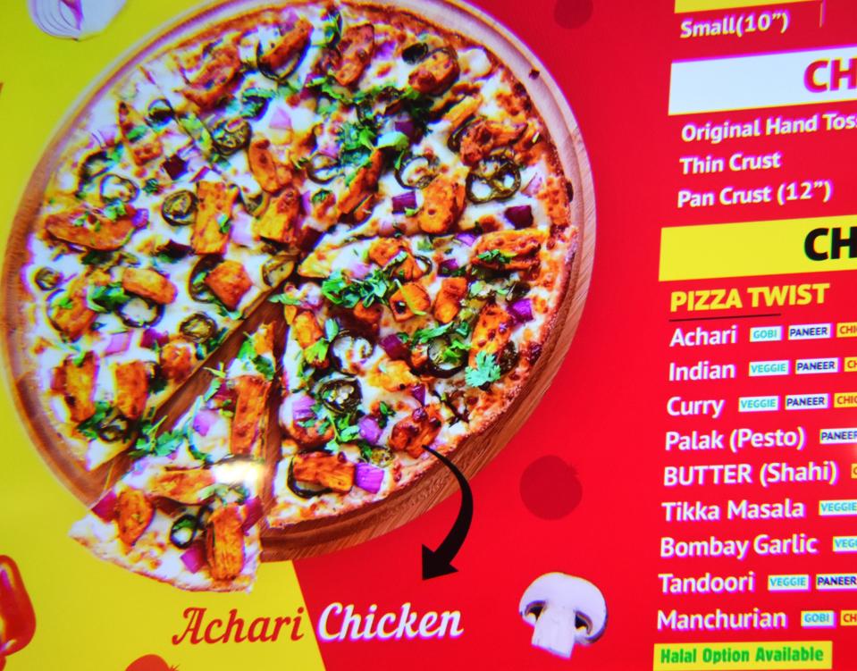 A menu sign shows toppings like tikka masala and Bombay garlic at Pizza Twist in Cherry Hill.
