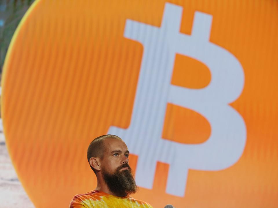 Square and Twitter CEO Jack Dorsey wearing a tye-dye shirt on stage in front of a bitcoin logo at a bitcoin convention in Miami, Floridia, on June 4, 2021.