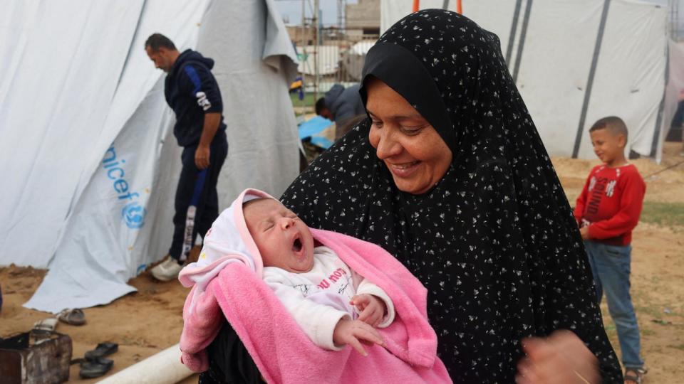 PHOTO: Mervat Salha, the grandmother of Palestinian baby girl Mariam who was war born during the conflict between Israel and Hamas, holds her outside a tent where they shelter in Rafah in the southern Gaza Strip, Dec. 17, 2023. (Saleh Salem/Reuters)