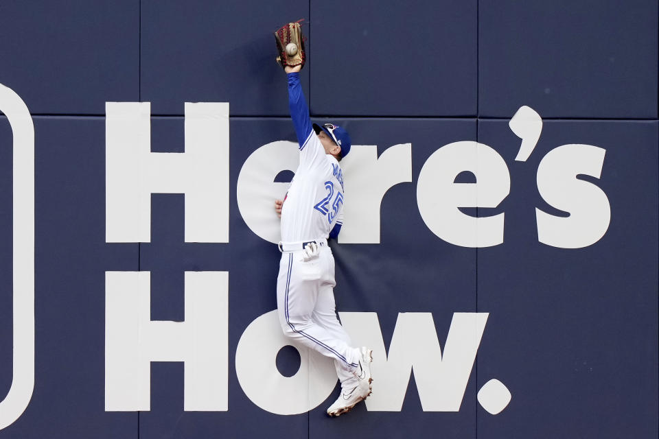 Toronto Blue Jays left fielder Daulton Varsho (25) makes a jumping catch on a hit by Kansas City Royals' Salvador Perez during the first inning of a baseball game in Toronto, Saturday, Sept. 9, 2023. (Nathan Denette/The Canadian Press via AP)