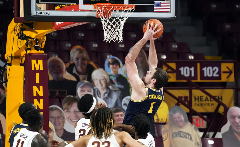 Michigan's Hunter Dickinson (1) shoots and scores as four against Minnesota players watch in the first half of an NCAA college basketball game, Saturday, Jan. 16, 2021, in Minneapolis. (AP Photo/Jim Mone)