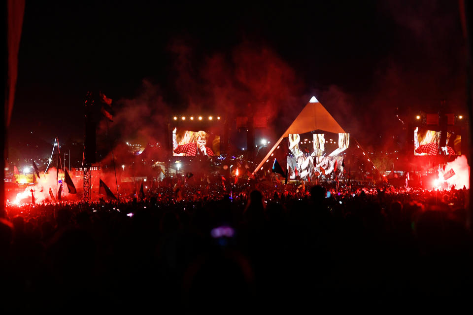 The Pyramid Stage is lit up in red as crowds watch Ed Sheeran perform in 2017.