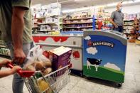 Customers walk near a refrigerator bearing the Ben & Jerry's logo at a food store in the Jewish settlement of Efrat in the Israeli-occupied West Bank