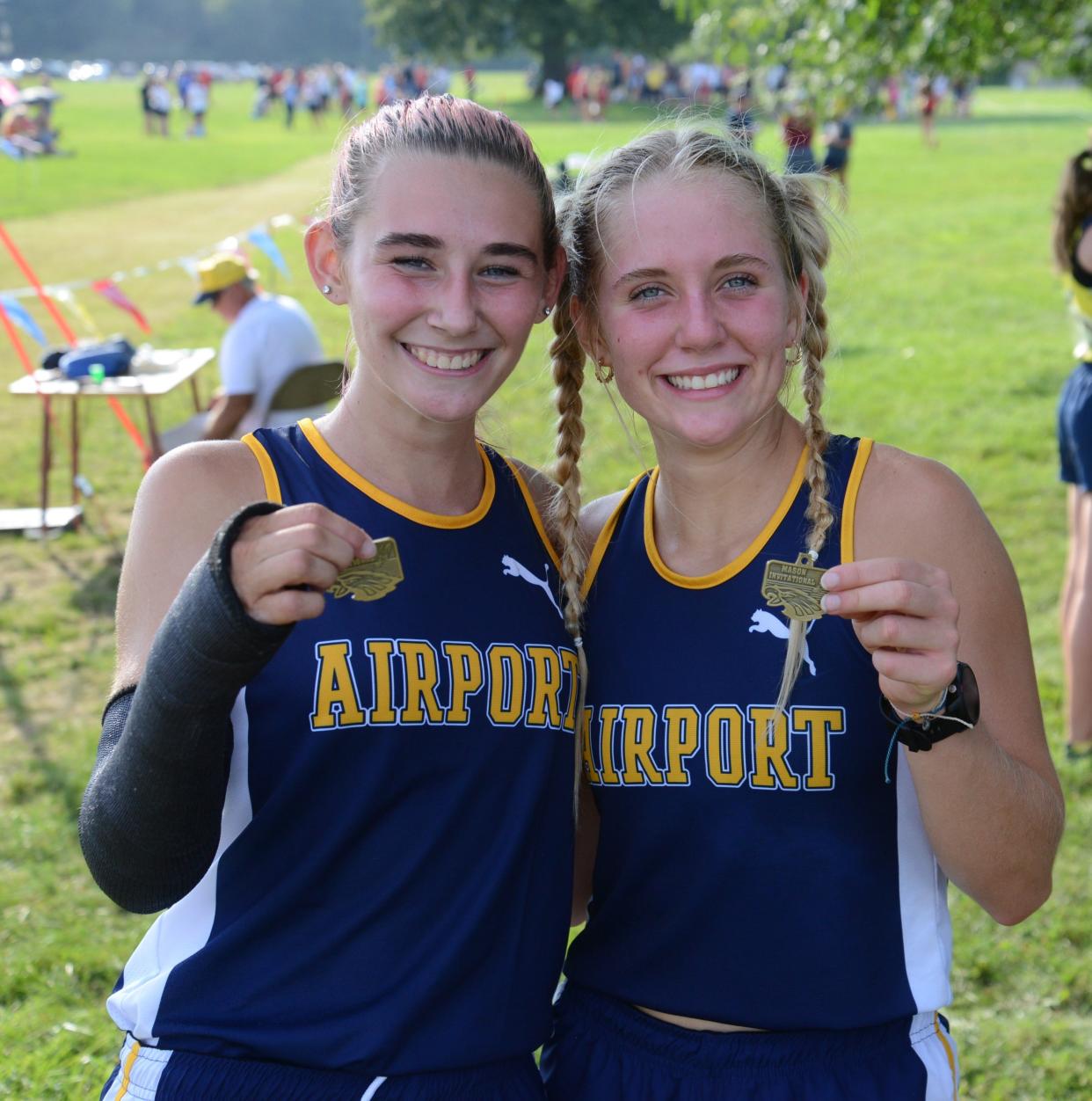 Cecilia Ortega (left) and Courtney Bovair of Jefferson show off their first-place medals in the 41st annual Frank Connolly Relays at Erie Mason. Ortega was running with a cast on her broken arm.