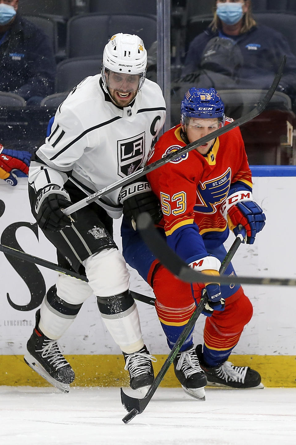 St. Louis Blues' Austin Poganski (53) handles the puck while under pressure from Los Angeles Kings' Anze Kopitar (11), of Slovenia, during the second period of an NHL hockey game Monday, Feb. 22, 2021, in St. Louis. (AP Photo/Scott Kane)