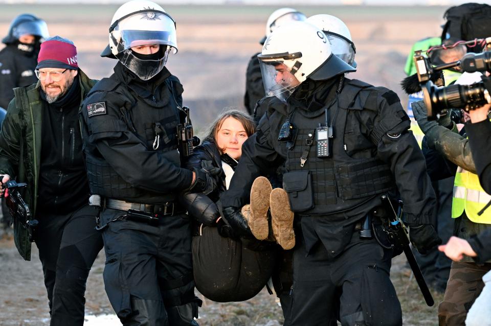 Police officers carry Swedish climate activist Greta Thunberg away from the edge of the Garzweiler II opencast lignite mine during a protest action by climate activists after the clearance of Luetzerath, Germany, Tuesday, Jan. 17, 2023. After the eviction of Luetzerath ended on Sunday, coal opponents continued their protests on Tuesday at several locations in North Rhine-Westphalia.