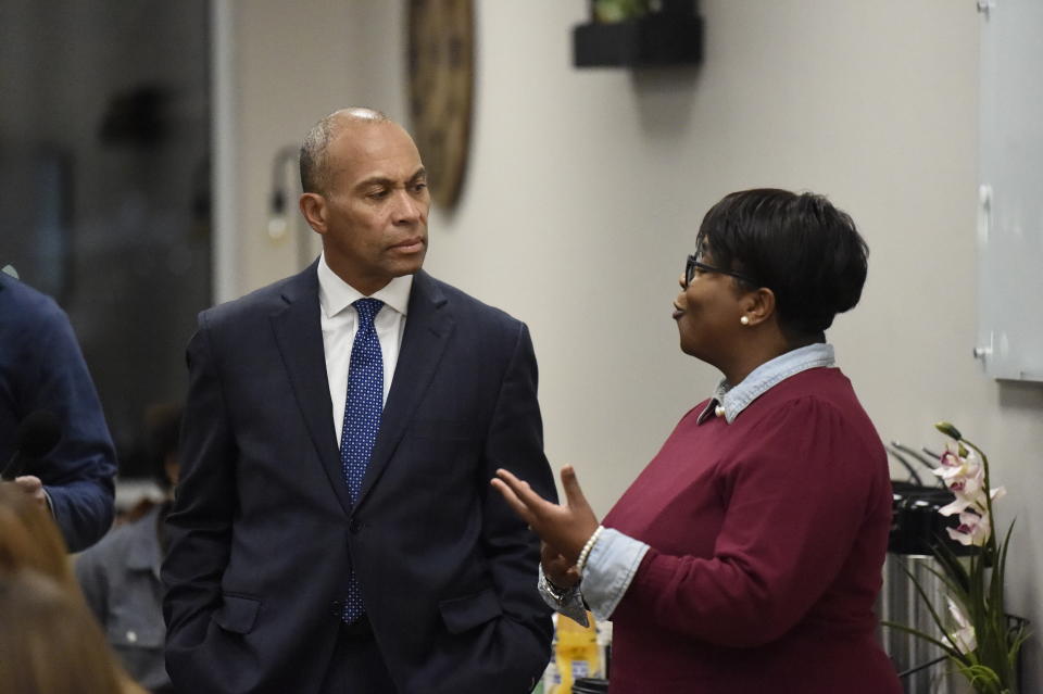 Former Massachusetts Gov. Deval Patrick, left, speaks with a business owner during a campaign stop, Tuesday, Nov. 19, 2019, in Columbia, S.C. (AP Photo/Meg Kinnard)