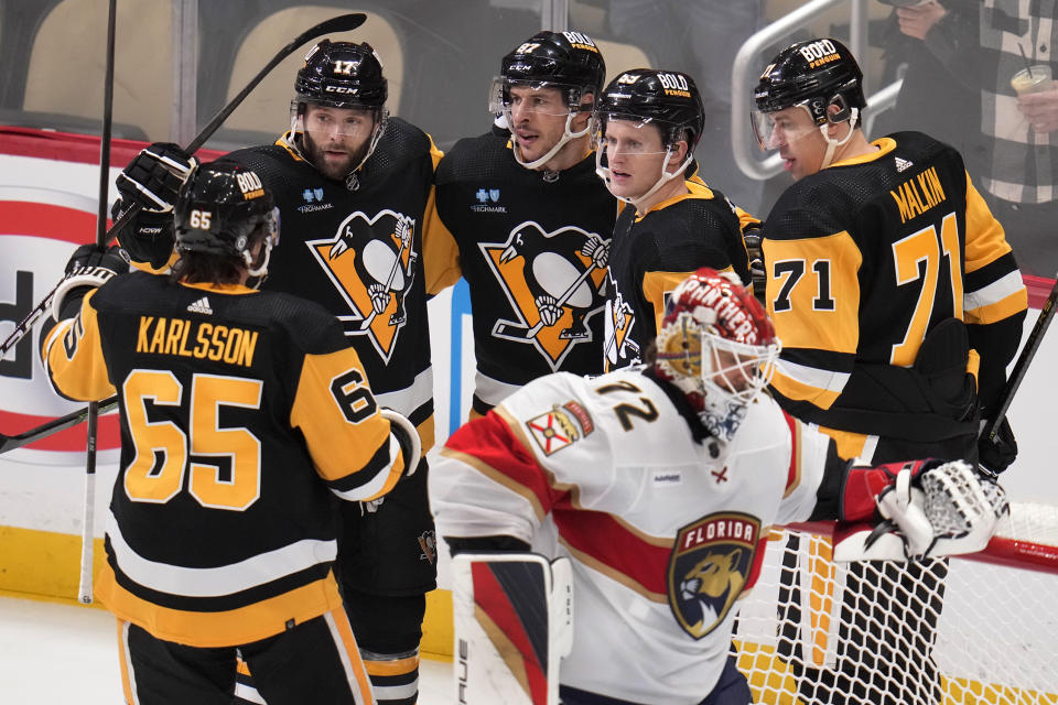 Pittsburgh Penguins' Jake Guentzel (59) celebrates his power-play goal with Erik Karlsson (65), Bryan Rust (17), Sidney Crosby (87), and Evgeni Malkin (71), while Florida Panthers goaltender Sergei Bobrovsky (72) collects himself during the first period of an NHL hockey game in Pittsburgh, Friday, Jan. 26, 2024. (AP Photo/Gene J. Puskar)