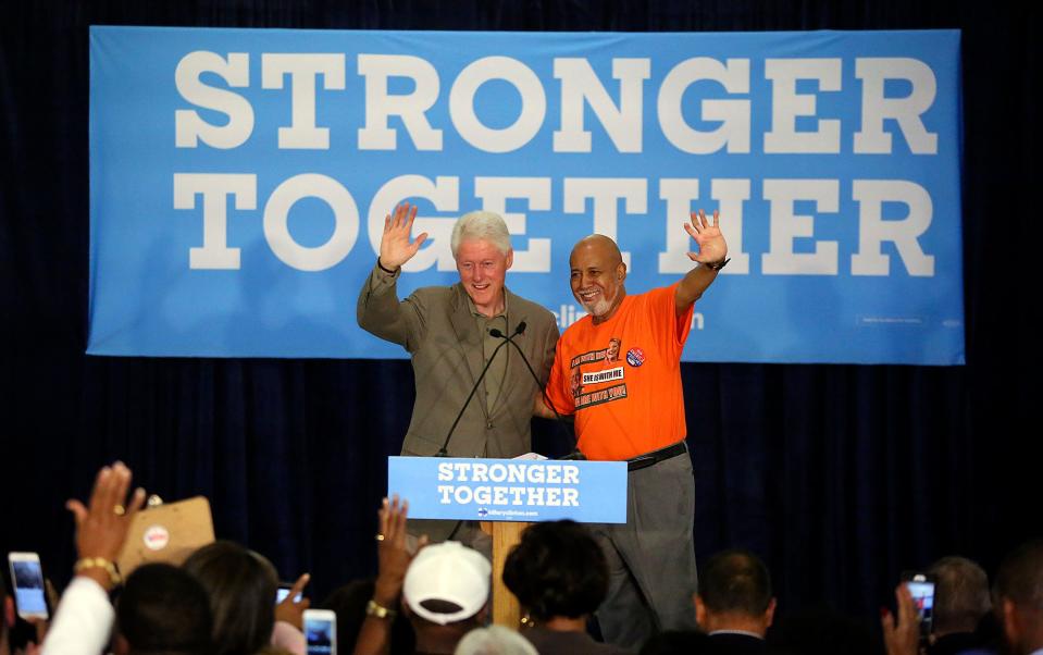 In this October 2016 image, former President Bill Clinton and the late U.S. Congressman Alcee Hastings wave to an audience at the Dolly Hand Cultural Arts Center in Belle Glade.