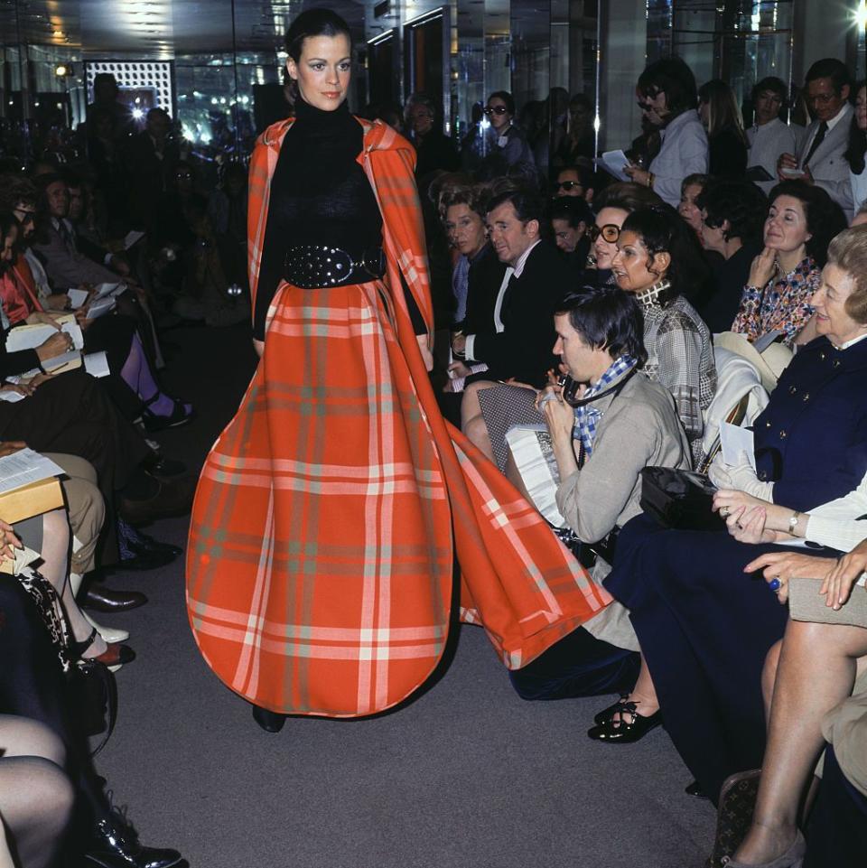 <p>Cardin's ready-to-wear collection showcased looks such as this oversized plaid skirt and matching cape, styled with a high-waisted belt.</p>