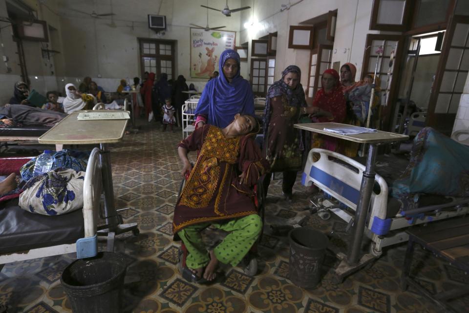 FILE - A pregnant woman is carried to the hospital for treatment after floods hit her home, in the Shikarpur district of Sindh Province, of Pakistan, Sep. 1, 2022. The flooding in Pakistan killed at least 1,700 people, destroyed millions of homes, wiped out swathes of farmland, and caused billions of dollars in economic losses. (AP Photo/Fareed Khan, File)