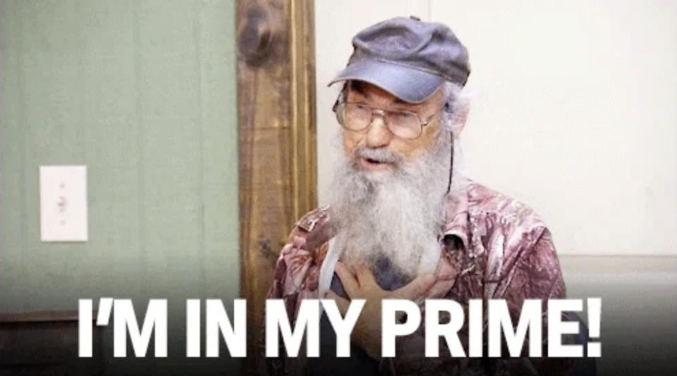 Man with long beard, wearing glasses and a cap, holds his chest. Text on the image says, "I'M IN MY PRIME!"