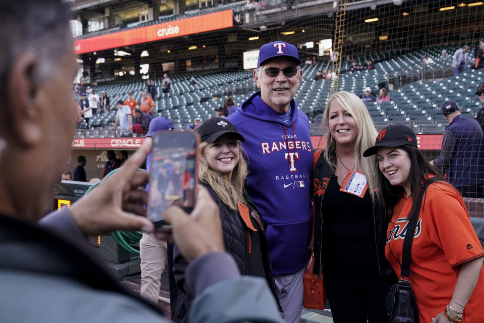 Texas Rangers manager Bruce Bochy, third from right, poses for a photograph with fans during batting practice before the team's baseball game against the San Francisco Giants, Friday, Aug. 11, 2023, in San Francisco. (AP Photo/Godofredo A. Vásquez)