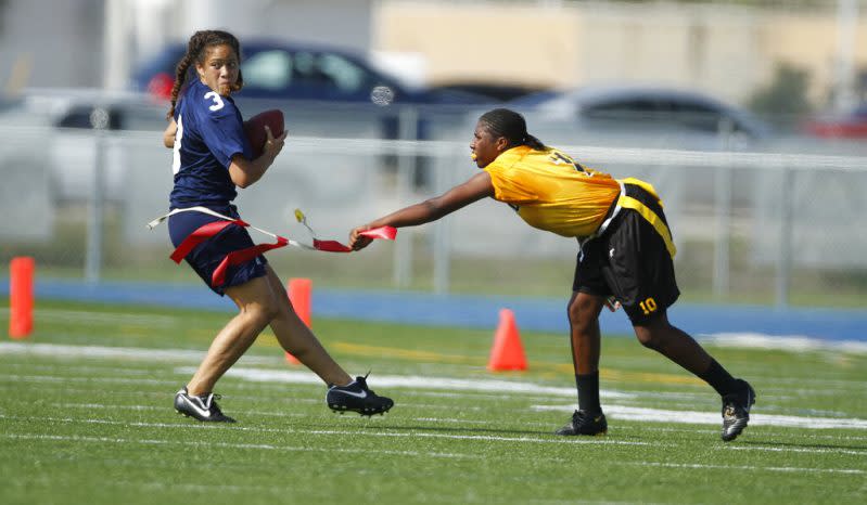 Lakewood’s Paige Johnson (10) pulls the flag off Alonso’s Sarah Peterika during a quarterfinal in the state high school flag football tournament in Boca Raton, Fla., Friday, May 7, 2010. An estimated 5,000 girls competed this spring at the varsity level in Florida, where the state has recognized a high school champion since 2003. (AP Photo/J Pat Carter)