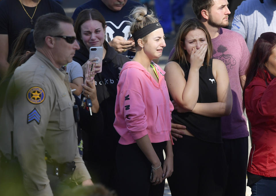 People cry as a law enforcement motorcade escorts the body of Ventura County Sheriff's Department Sgt. Ron Helus from the Los Robles Regional Medical Center Thursday, Nov. 8, 2018, in Thousand Oaks, Calif., after a gunman opened fire Wednesday evening inside a country music bar, killing multiple people including Helus. (AP Photo/Mark J. Terrill)