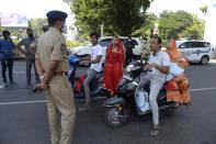 Police personnel enquire people as they travel during a one-day nationwide Janata (civil) curfew imposed as a preventive measure against the COVID-19 coronavirus, in Hyderabad on March 22, 2020. - Nearly one billion people around the world were confined to their homes, as the coronavirus death toll crossed 13,000 and factories were shut in worst-hit Italy after another single-day fatalities record. (Photo by NOAH SEELAM / AFP) (Photo by NOAH SEELAM/AFP via Getty Images)