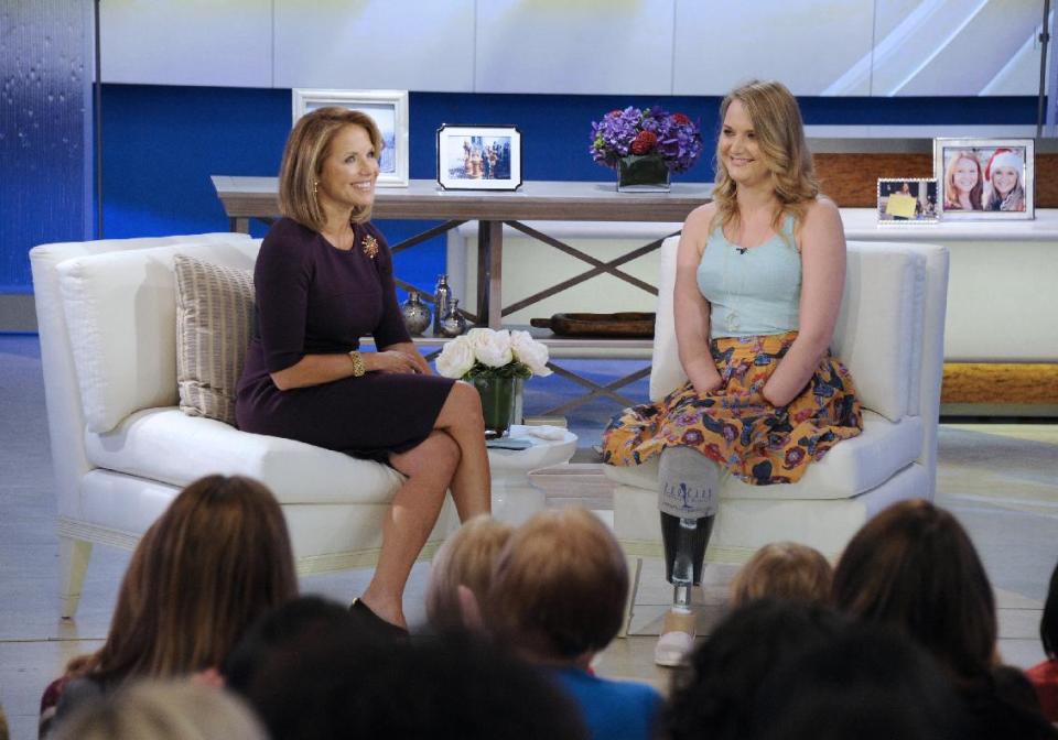 This image released by Disney-ABC Domestic Television shows host Katie Couric, left, with Aimee Copeland, 24, of Snellville, Ga., who survived a rare fleshing-eating disease, during an exclusive interview on the new daytime talk show "Katie," Tuesday, Sept. 11, 2012 in New York. Copeland walked to the stage using a new walker. Copeland was joined in New York by her parents and sister. After Couric interviewed the family, she announced that an Atlanta-area Chevrolet dealer was in the studio to give Copeland a new minivan that will be retrofitted so she can drive it. Copeland got the infection in May after falling from a zip line and gashing her leg. Doctors had to amputate both hands, her left leg and right foot. She returned home to suburban Atlanta last week after three months in the hospital and a rehabilitation clinic. (AP Photo/Disney-ABC Domestic Television, Ida Mae Astute)