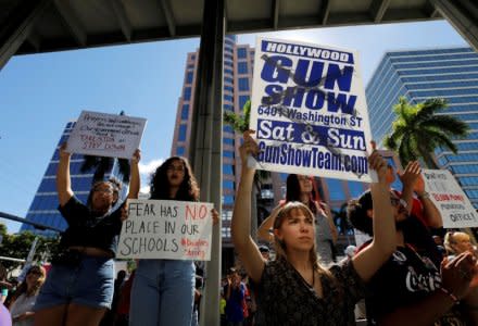 A protester holds a defaced placard at a rally calling for more gun control three days after the shooting at Marjory Stoneman Douglas High School, in Fort Lauderdale, Florida, U.S.,February 17, 2018. REUTERS/Jonathan Drake