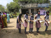 Schoolgirls carry boxes of packaged food and sweets sent by a non-government organization to be distributed among school children and villagers ahead of the inauguration of U.S. Vice President-elect Kamala Harris, in Thulasendrapuram, the hometown of Harris' maternal grandfather, south of Chennai, Tamil Nadu state, India, Tuesday, Jan. 19, 2021. The inauguration of President-elect Joe Biden and Vice President-elect Kamala Harris is scheduled be held Wednesday. (AP Photo/Aijaz Rahi)