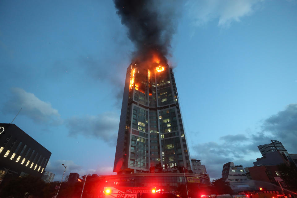 An apartment building is engulfed in a fire in Ulsan, South Korea, Friday, Oct. 9, 2020. A fire spread through the high-rise apartment building in the port city early Friday, causing minor injuries to scores of people, officials said. (Kim Yong-tae/Yonhap via AP)