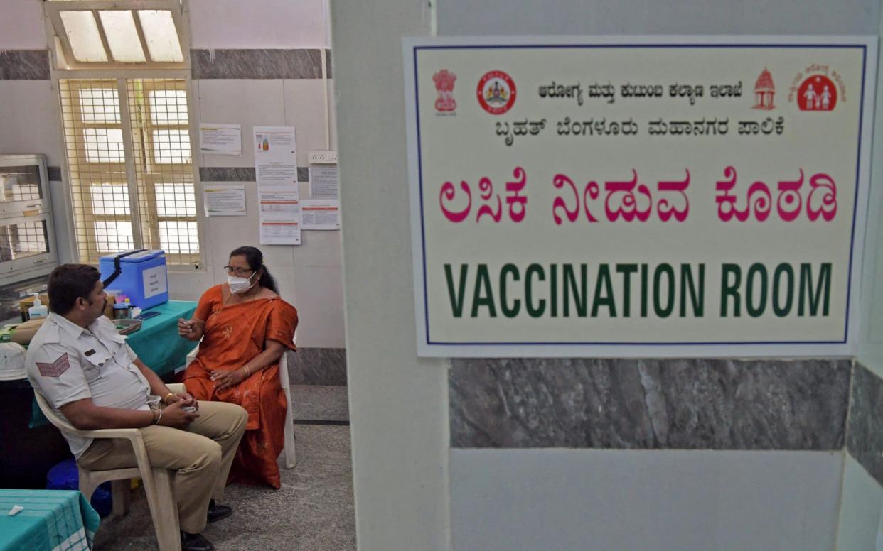 A medical worker preparing to give a Covid-19 jab to a policeman in Bangalore, India - Manjunath Kiran/AFP