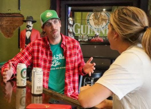 Jake Sapp sits at a bar with his Peach State Lite beer, which is finding a home in convenience stores across the region.