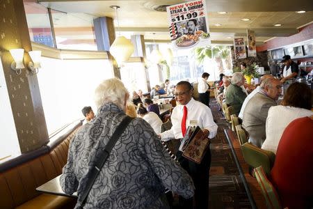 A waitress seats customers dining at Norms Diner on La Cienega Boulevard in Los Angeles, California May 20, 2015. REUTERS/Patrick T. Fallon