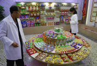 In this Oct. 22, 2018, photo, Kwon Yong Chol, left, the chief engineer at the Songdowon General Foodstuffs Factory, shows samples of products at his facility in Wonsan, North Korea. Though the international spotlight has been on his denuclearization talks with Washington, the North Korean leader has a lot riding domestically on his promises to boost the country's economy and standard of living. His announcement in April that North Korea had sufficiently developed its nuclear weapons and would now focus on building its economy marked a sharp turn in official policy and set the stage for his rapid-fire meetings with the leaders of China, South Korea and the United States. (AP Photo/Dita Alangkara)