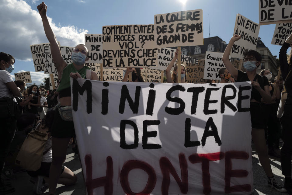 Women's rights activists protest against French President Emmanuel Macron's appointment of an interior minister who has been accused of rape and a justice minister who has criticized the #MeToo movement, in front of Paris city hall, in Paris, France, Friday, July 10, 2020. The French government said it remains committed to gender equality and defended the new ministers, stressing the presumption of innocence. Gerald Darmanin, Interior Minister, firmly denies the rape accusation, and an investigation is underway. New Justice Minister Eric Dupond-Moretti is a lawyer who has defended a government member accused of rape and sexual assault, and has ridiculed women speaking out thanks to the #MeToo movement. (AP Photo/Francois Mori)