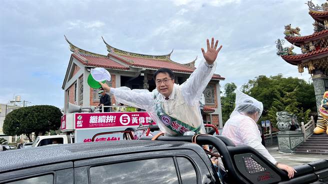 台南市長黃偉哲24日車隊遊行，一早從北門區仁安宮啟程，即使天空細雨綿綿，黃偉哲穿雨衣照規畫行程出發。（張毓翎攝）