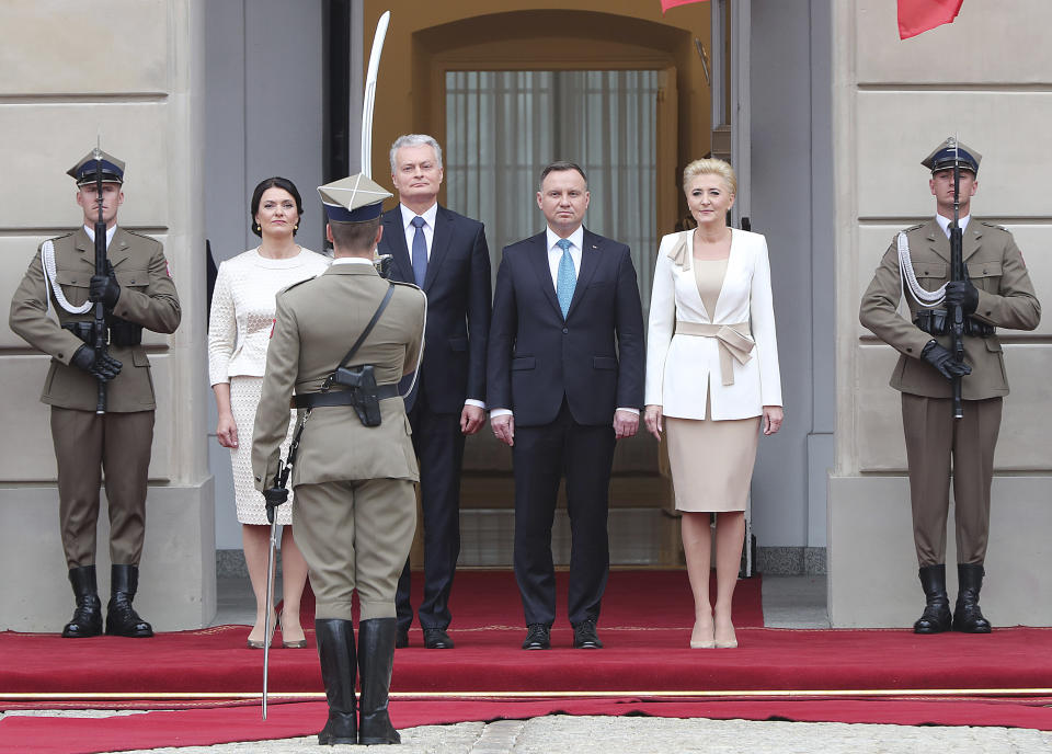 Lithuanian First Lady Diana Nausediene, from left, Lithuanian President Gitanas Nauseda, his Polish counterpart Andrzej Duda and Poland's First Lady Agata Kornhauser-Duda attend a military welcome ceremony at the presidential Palace in Warsaw, Poland, Tuesday, July 16, 2019.(AP Photo/Czarek Sokolowski)