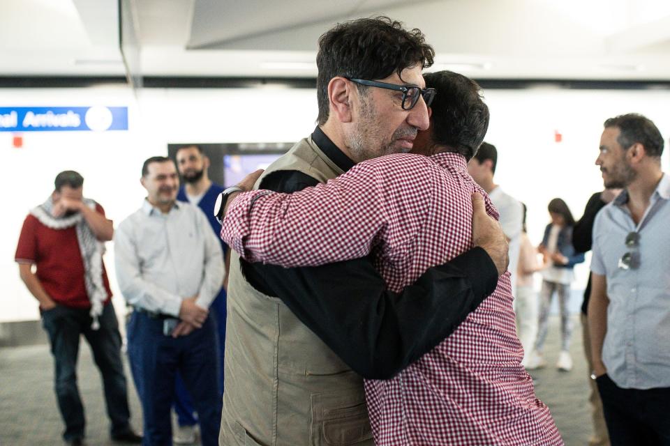 Dr. Ammar Ghanem hugs his friend Tarek Atasi after arriving at Detroit Metro Airport in Romulus on Saturday, May 18, 2024.