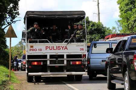 A truck carrying armed policemen drive along a main highway of Pantar town, Lanao Del Norte, as they travel to reinforce Marawi city, southern Philippines May 24, 2017. REUTERS/Romeo Ranoco