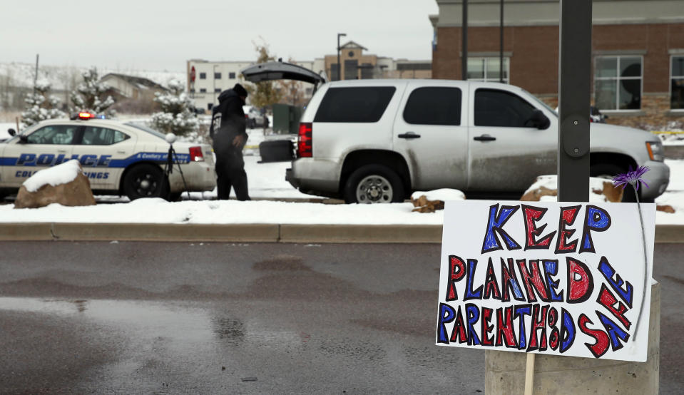 FILE - In this Nov. 29, 2015 file photo, a sign in support of Planned Parenthood is placed nearby as police investigators gather evidence near the scene of a shooting at the clinic in Colorado Springs, Colo. Harassment and violence have become common outside abortion clinics over the decades since the landmark 1973 ruling legalizing abortion. Now providers and some in law enforcement worry what will come next. (AP Photo/David Zalubowski, File)