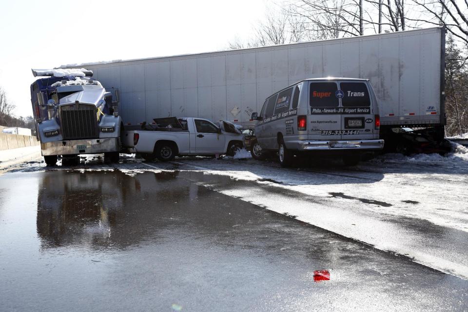 Vehicles are piled up in an accident, Friday, Feb. 14, 2014, in Bensalem, Pa. Traffic accidents involving multiple tractor trailers and dozens of cars have completely blocked one side of the Pennsylvania Turnpike outside Philadelphia and caused some injuries. (AP Photo/Matt Rourke)