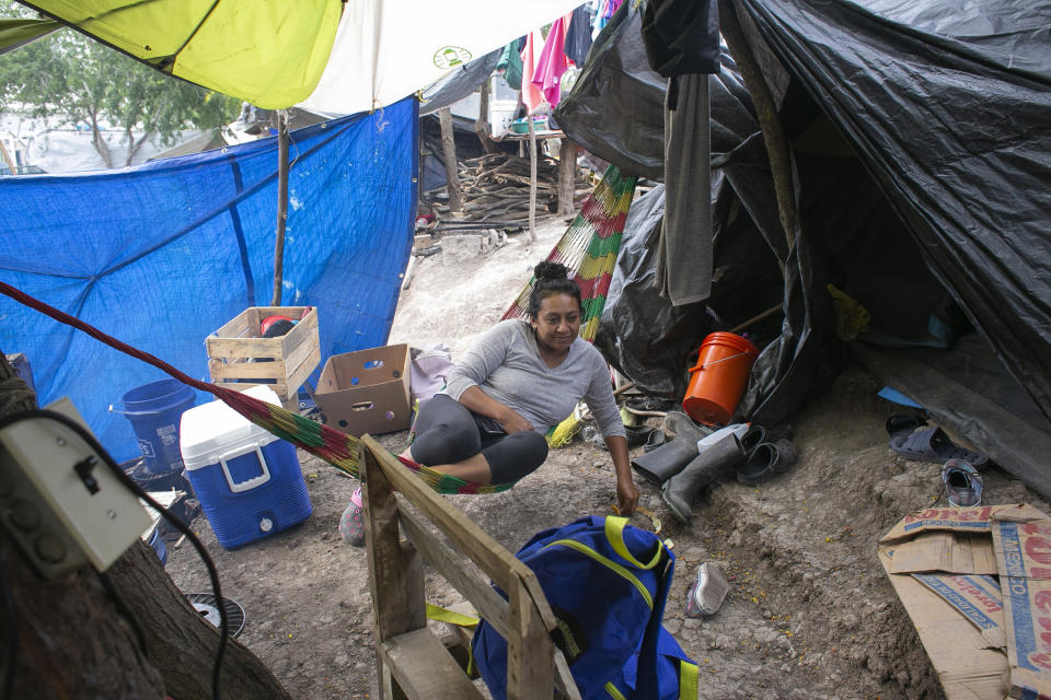 FILE - In this Tuesday, April 14, 2020 file photo, Lillian Morales lies in a hammock inside a shared shelter at the migrant encampment outside El Puente Nuevo in Matamoros, Mexico. Since the U.S. government's decision on March 20 to close the U.S.-Mexico border to nonessential travel, there are reports of some residents self deporting as the asylum system is put on hold. (Denise Cathey/The Brownsville Herald via AP)