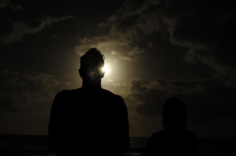 PALM COVE, AUSTRALIA - NOVEMBER 14: A spectator views the solar eclipse on November 14, 2012 in Palm Cove, Australia. Thousands of eclipse-watchers have gathered in part of North Queensland to enjoy the solar eclipse, the first in Australia in a decade. (Photo by Ian Hitchcock/Getty Images)