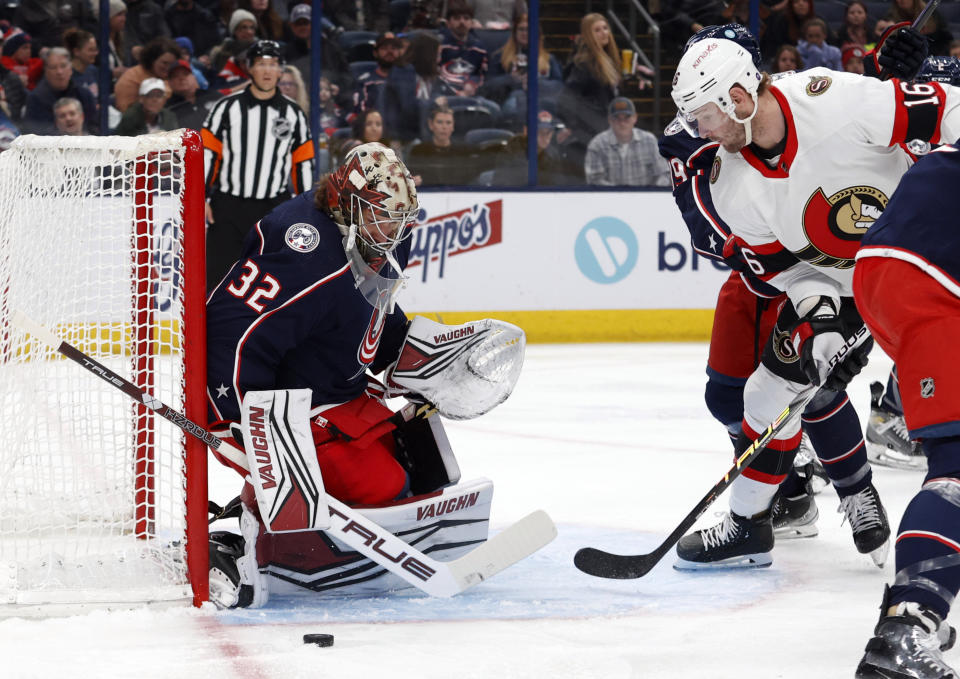 Columbus Blue Jackets goalie Jon Gillies, left, makes a stop in front of Ottawa Senators forward Austin Watson (16) during the first period of an NHL hockey game in Columbus, Ohio, Sunday, April 2, 2023. (AP Photo/Paul Vernon)