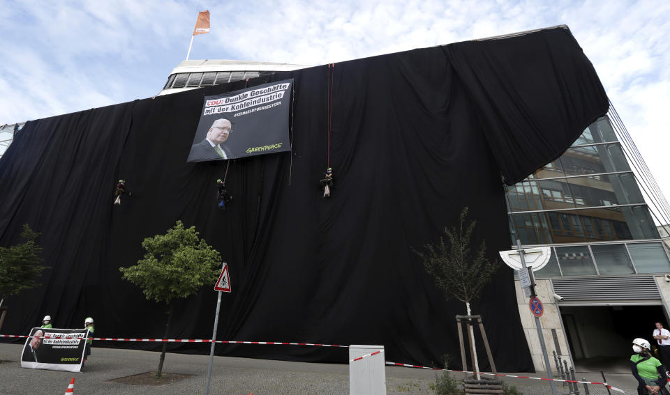 Activists of Greepeace have covered the headquarters of German Chancellor Angela Merkel's Cristian Democratic Party (CDU) with black panels to protest against the party's coal policy in Berlin, Germany, Wednesday, July 1, 2020. (AP Photo/Michael Sohn)