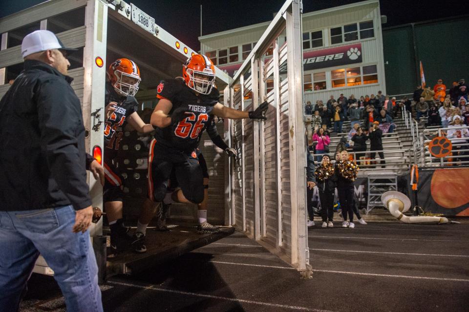 Byron's Jake Kann, 66, and Colton Weick, 64, lead the Byron frontline off the hog trailer before their playoff game against Lisle on Friday, Oct. 28, 2022. Byron went on to win 52-7.