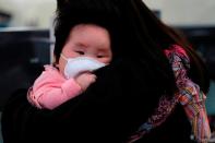 A child wears mask to prevent an outbreak of a new coronavirus at the Hong Kong West Kowloon High Speed Train Station, in Hong Kong