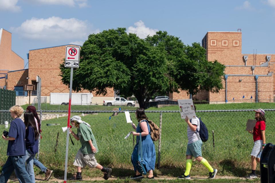 Some students marched about a mile around the McCallum High campus perimeter on Monday chanting, “Students together can make the world better.”